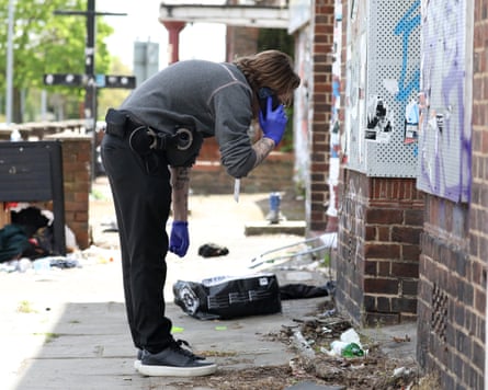 Police officer wearing gloves examines a shopfront