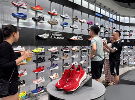 Customers shop for shoes at a Nike shop in Hanoi, Vietnam