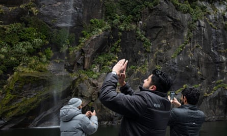 Visitors take pictures from a cruise ship in Milford Sound.