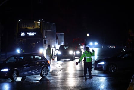 Police direct cars during a pitch black night