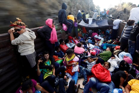 Central American migrants, moving in a caravan through Mexico, journey an open wagon of a freight train after stopping it on the rail line, in Hidalgo state, 14 April