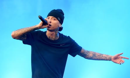Central Sea performs at Leeds Festival 2023 in a beanie and black T-shirt. he has tattoos on both arms