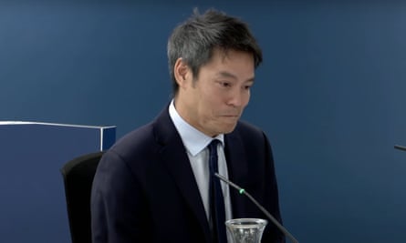 Screengrab of Kevin Fong looking emotional while giving evidence sitting at a table
