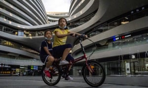 Two children ride a bike at a shopping mall in Beijing, China on 19 July 2020.