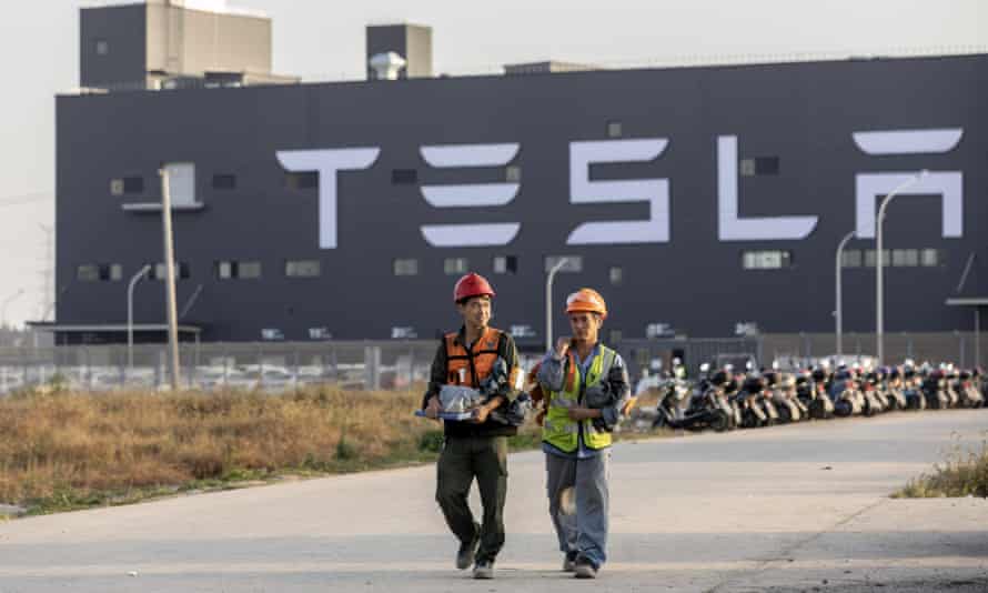 Workers walk in front of Tesla Gigafactory in Shanghai, China, November 2019.