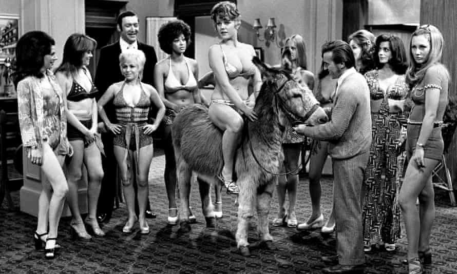 Margaret Nolan (riding the donkey) in Carry On Girls, 1973, with Bernard Bresslaw, third from left, Wendy Richard, second from left, and Barbara Windsor, third from left, front, during a beauty contest scene in Carry On Girls, 1973.