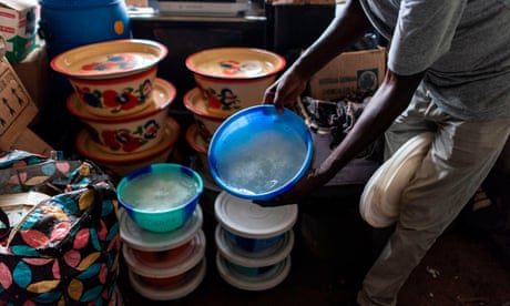 A National Drug Law Enforcement Agency official with one of 18 tubs of methamphetamine found at a lab in a village in south-east Nigeria