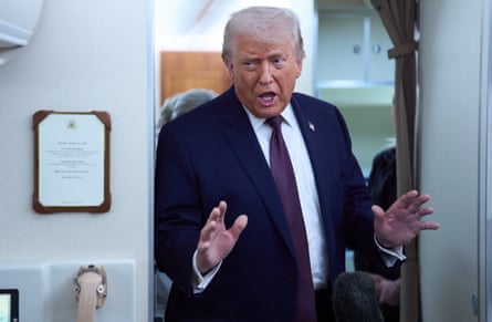 Donald Trump speaks while standing in a doorway on the plane