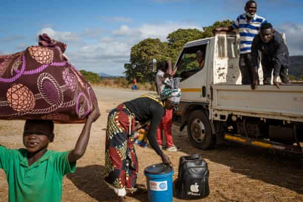 Displaced people climb out of a pick up truck Cabo Delgado.