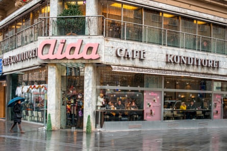 The cafe viewed from outside with people sitting on high stools in its windows