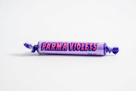 A purple candy roll wrapper labelled "Parma Violets" lies on a white background