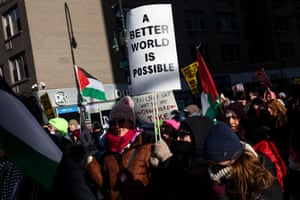 a person holds a sign that reads ‘a better world is possible’ in a crowd of people outside