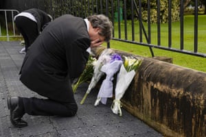 A man reacts after laying flowers outside Government House in Sydney, Australia.