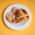 An Asda Exceptional lemon & white chocolate hot cross bun, sliced, toasted and buttered, on a white plate