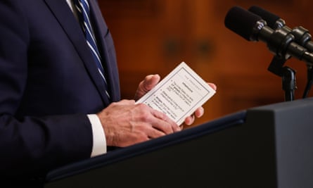 Joe Biden holds a note card as he delivers remarks during the first formal press conference of his presidency.