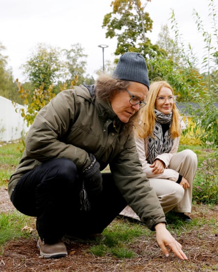 A man and a woman crouch on the ground