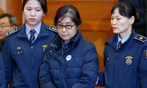 Police officers flank Choi Soon-sil, the woman at the centre of the South Korean political scandal and long-time friend of Park Geun-hye.