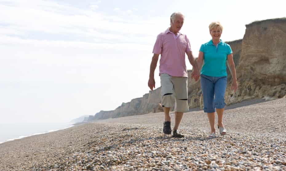 mature couple walking on shingle beach