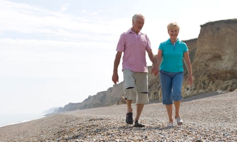 Mature couple walking on shingle beach