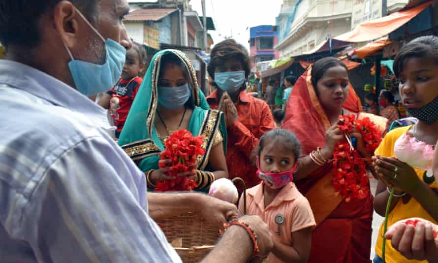 People wearing masks worship outside a closed temple in Kolkata.