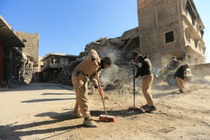 People clean streets in Mosul, Iraq