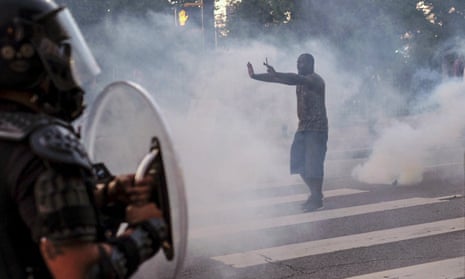 A protester tries to talk the police back amid teargas in downtown Atlanta on 25 May.