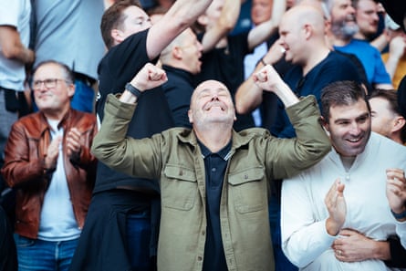 West Ham supporter looks to the sky and clenches fists in elation as West Ham score a goal.