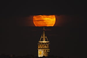 The moon behind the Galata Tower in Istanbul, Turkey,