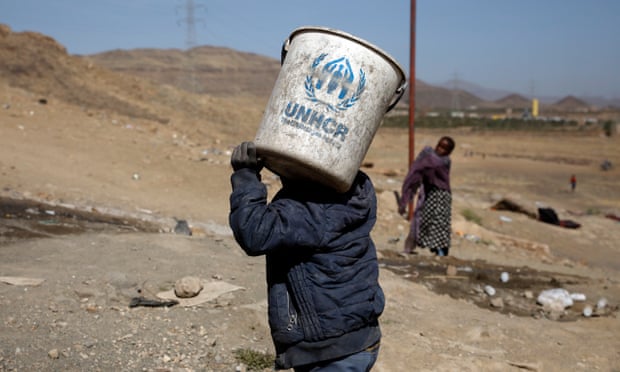 A displaced Yemeni boy carries a UNHCR bucket at a camp for Internally Displaced Persons (IDPs) on the outskirts of Sana’a, Yemen, 1 March 2021.