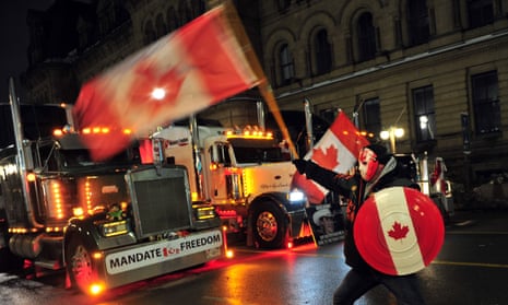 man in mask with canadian flag in front of a truck