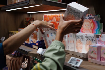 Customers reach out for boxes with toy figures in the first Pop Mart store selling Labubu toys in Berlin, Germany,