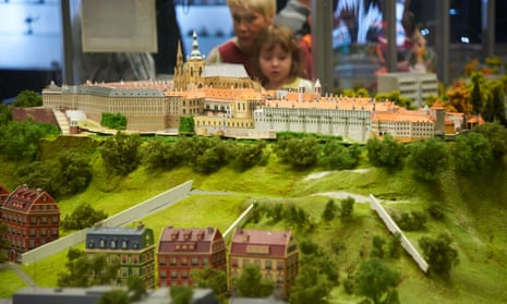 Prague’s Kingdom of Railways features model trains running around miniature versions of Czech cities. A mother and her daughter watch one run around Prague castle.