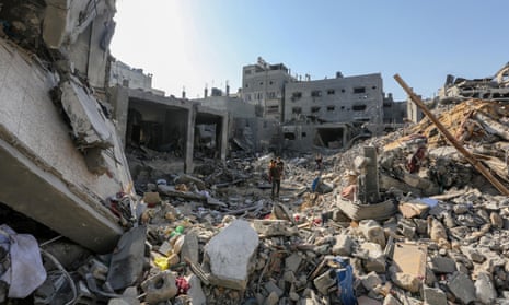 People search through buildings that were destroyed during Israeli air raids on the southern Gaza Strip.