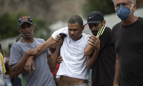 Alexsandro dos Santos, center, is helped by friends during the burial of his four-year-old daughter Emily Victoria Silva dos Santos/