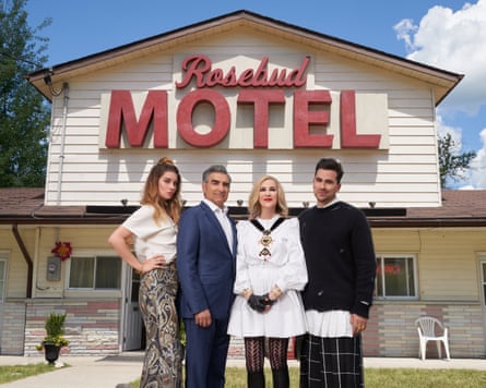 A promotional still for Schitt’s Creek, with the lead characters stood in front of the Rosebud Motel.