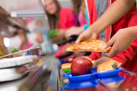 School children getting food in the cafeteria line.