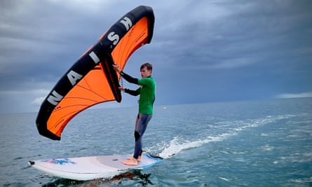 A young man wing surfing on Beadnell Bay