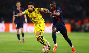 Nuno Mendes of Paris Saint-Germain runs with the ball whilst under pressure from Jadon Sancho