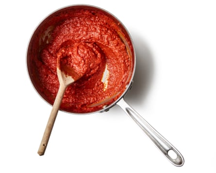 Tomato sauce in a pan with a wooden spoon