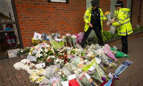 Police officers arrange flowers and tributes to David Amess outside Belfairs Methodist church in Eastwood Road North, Leigh-on-Sea, Essex