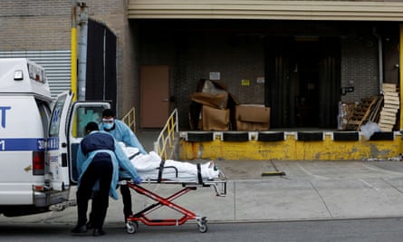 Healthcare workers load a patient into an ambulance in Brooklyn.