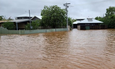 Two houses inundated with brown flood water