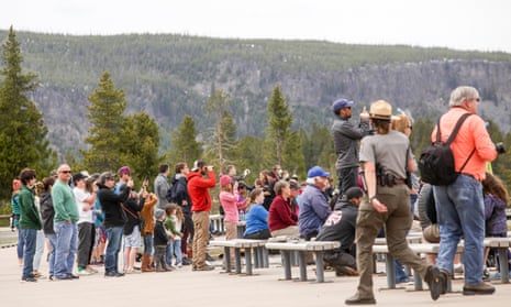Visitors watch Old Faithful erupt on Monday afternoon on Yellowstone national park’s opening day.