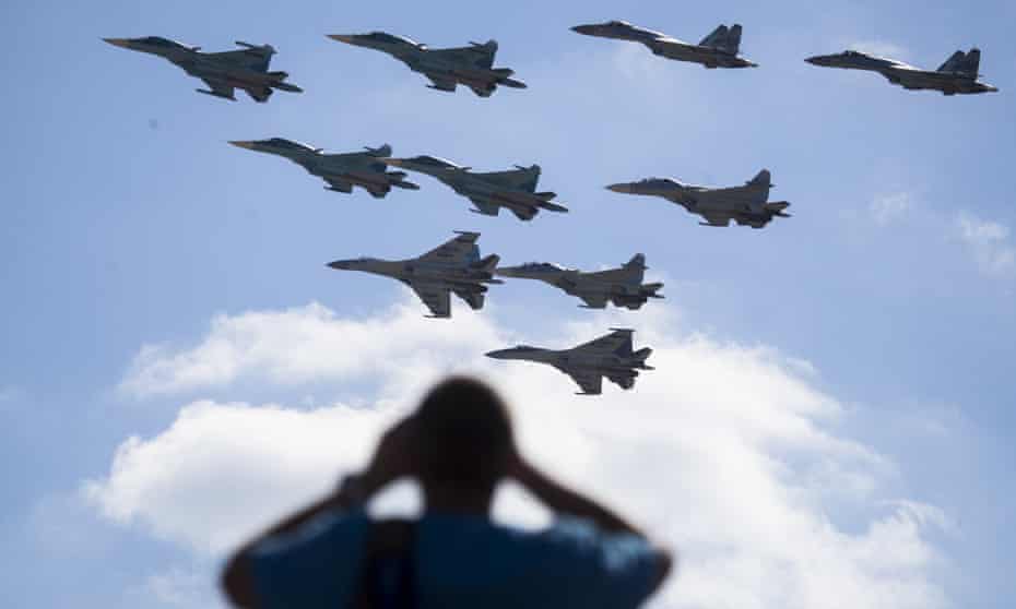 A man watches Russian military jets performing in Alabino