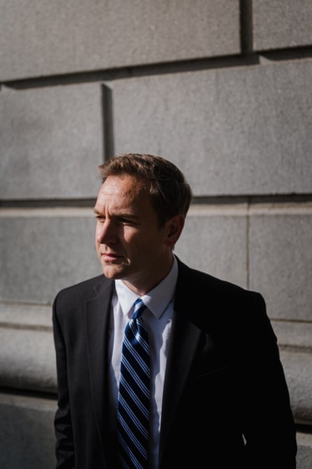 man in suit stands outside building and looks ahead