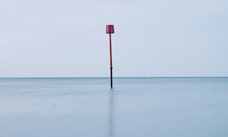 A tall pole sticking up from the sea