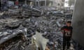  A Palestinian child walks among the rubble of buildings destroyed by Israeli attacks.