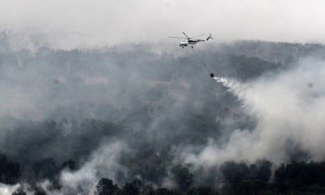 A MI-17 helicopter run by the Indonesian National Disaster Mitigation Agency water-bombs a fire in South Sumatra province