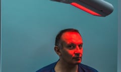 Dr Bav Shergill - Consultant Dermatologist - with a red light shining on his face