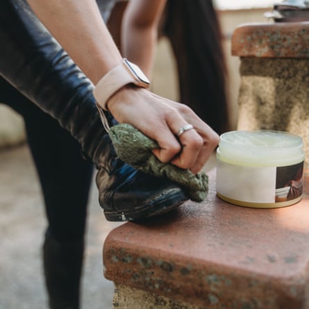 A woman is polishing boots before riding. Selective focus on the hand.